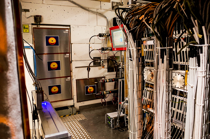 The MoEDAL experiment includes the blue light and the plastic sheets on the wall. The LHC’s collision point is on the right. Photo: Ryan F. Mandelbaum/Gizmodo.